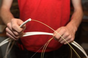 Närbild på en tekniker som håller upp en fiberkabel